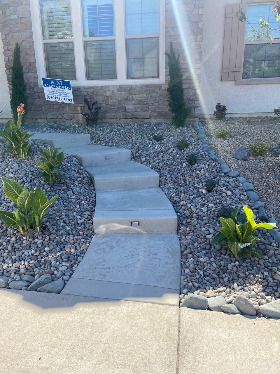 Finished concrete steps and walkway through rock landscaping